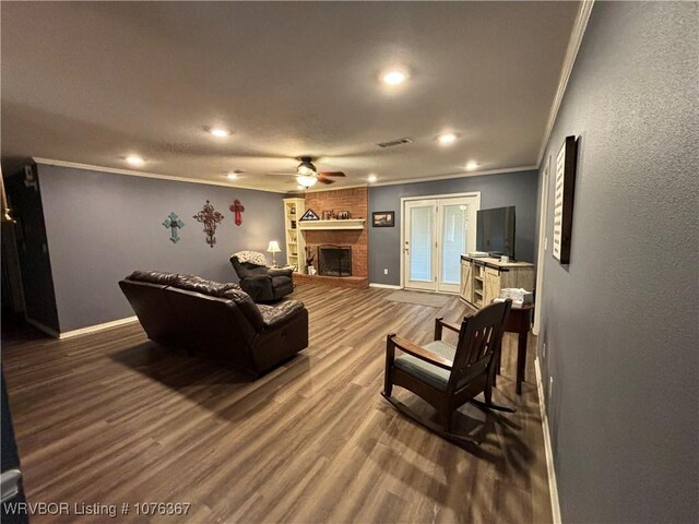 living room with a fireplace, hardwood / wood-style flooring, ceiling fan, and ornamental molding