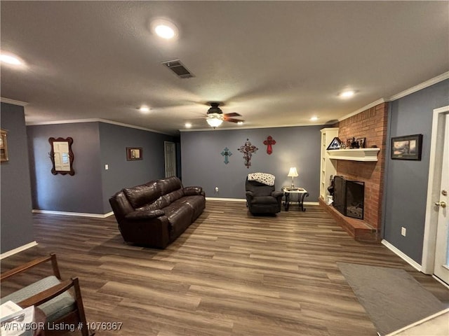 living room with a fireplace, hardwood / wood-style flooring, ceiling fan, and crown molding