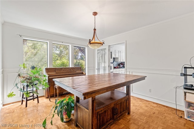 dining area with ornamental molding and light parquet flooring