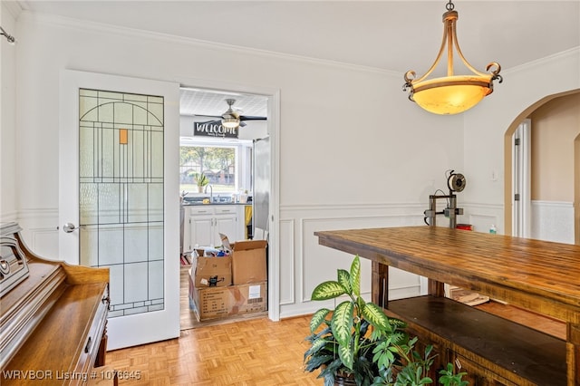 dining area with light parquet floors, ceiling fan, and ornamental molding