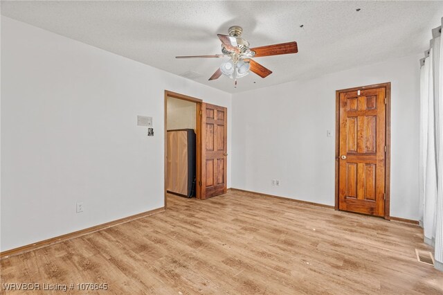 unfurnished bedroom with ceiling fan, light wood-type flooring, and a textured ceiling