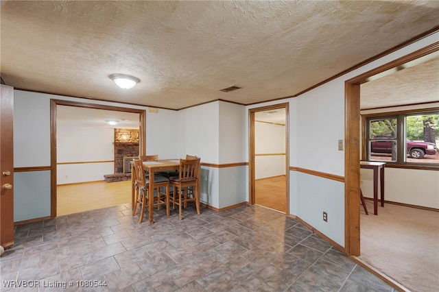 dining area with baseboards, visible vents, stone finish flooring, and a textured ceiling