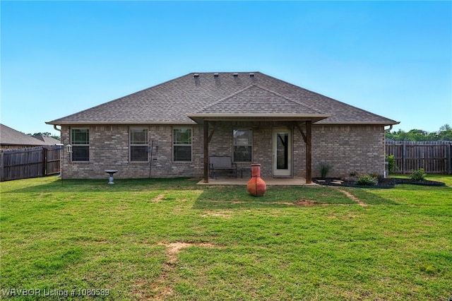 1026 Snow Goose Way, Barling, AR 72923 - back of house with a shingled roof, brick siding, a fenced backyard, a lawn, and a patio