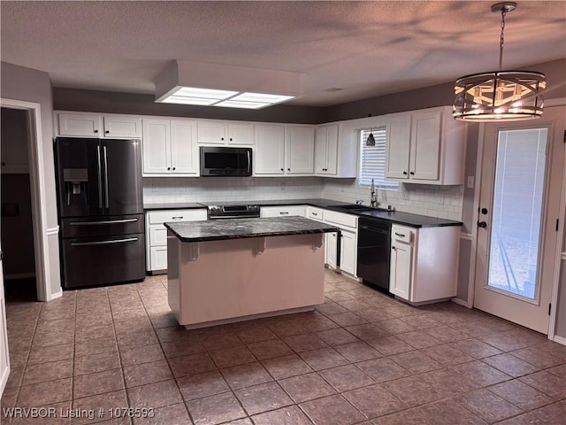 kitchen with hanging light fixtures, black appliances, sink, and white cabinets