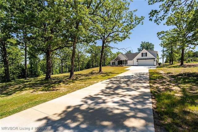 view of front facade featuring an attached garage, driveway, and a front yard