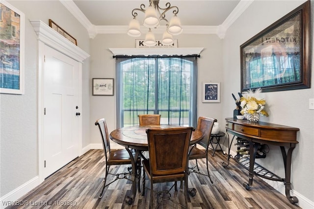 dining area with baseboards, ornamental molding, a chandelier, and wood finished floors