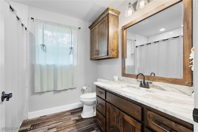 bathroom with baseboards, toilet, a shower with shower curtain, vanity, and wood finished floors