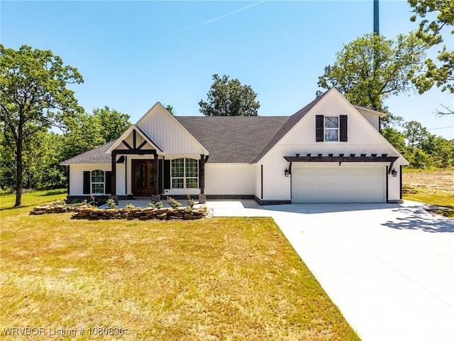 modern farmhouse with driveway, roof with shingles, a front lawn, and a garage