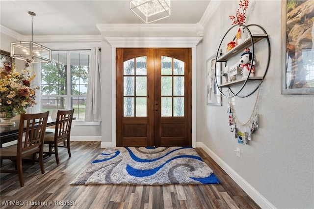 foyer with a chandelier, crown molding, baseboards, and wood finished floors