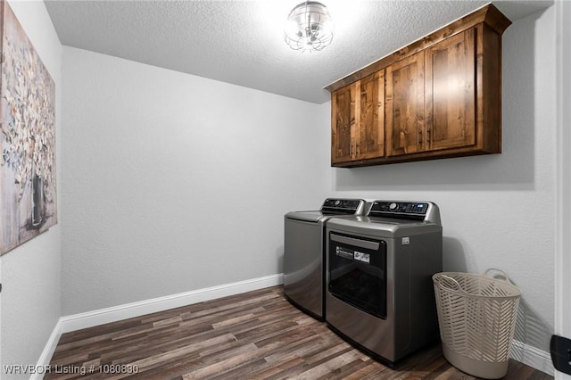 clothes washing area with cabinet space, dark wood-type flooring, baseboards, and washer and dryer