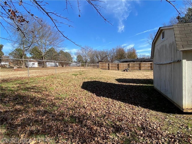 view of yard with a fenced backyard, a shed, and an outdoor structure