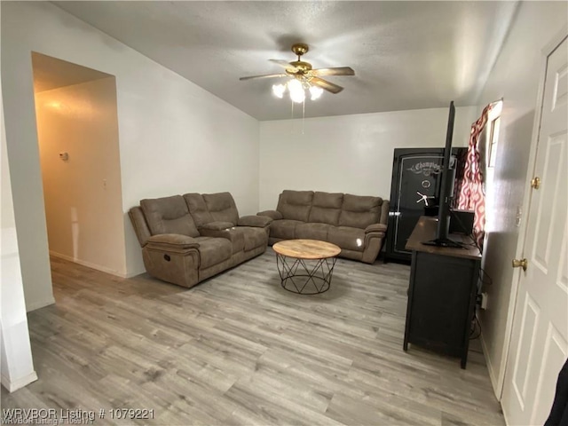 living area with a ceiling fan, light wood-style flooring, and baseboards