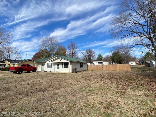 exterior space featuring metal roof and fence