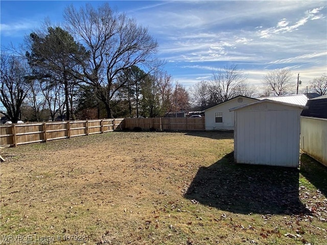 view of yard with a fenced backyard, an outdoor structure, and a shed