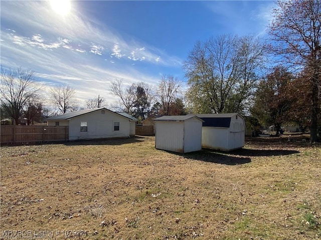 exterior space with a storage shed, fence, and an outdoor structure