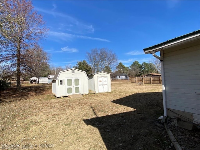 view of yard with an outbuilding, a storage unit, and fence