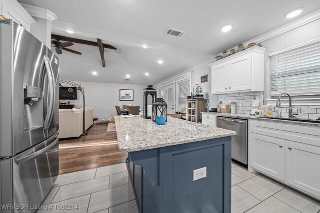 1024 Mourning Dove Way, Barling, AR 72923 - kitchen featuring appliances with stainless steel finishes, a ceiling fan, open floor plan, a center island, and white cabinetry