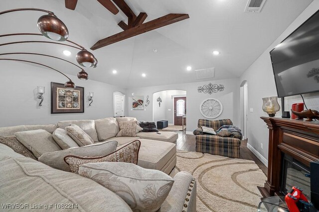 1024 Mourning Dove Way, Barling, AR 72923 - living room with arched walkways, wood finished floors, beamed ceiling, recessed lighting, and a glass covered fireplace