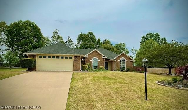 ranch-style house featuring concrete driveway, a garage, and a front lawn