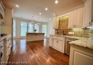 kitchen with dark wood finished floors, recessed lighting, backsplash, dishwasher, and a sink