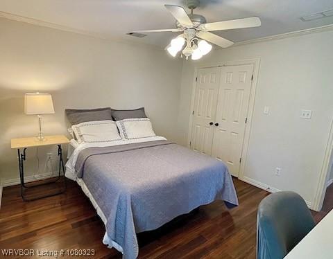 bedroom with a closet, ceiling fan, crown molding, baseboards, and wood finished floors