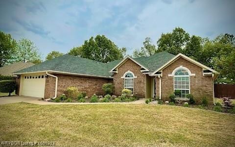 single story home featuring brick siding, a front lawn, driveway, and an attached garage