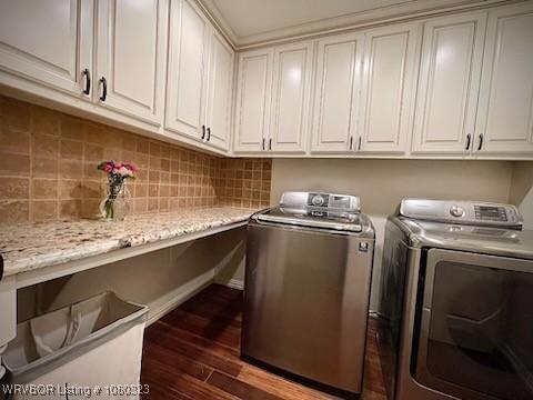 laundry room featuring dark wood-style floors, cabinet space, and independent washer and dryer