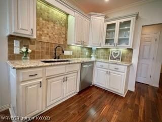 kitchen featuring stainless steel dishwasher, glass insert cabinets, backsplash, a sink, and white cabinetry