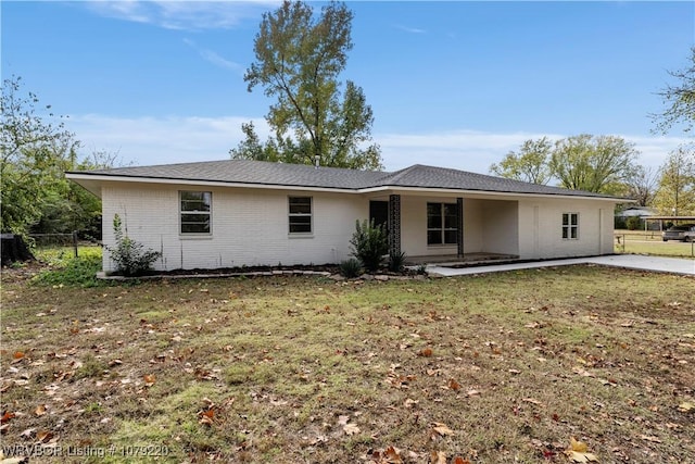 single story home with brick siding, fence, and a front lawn