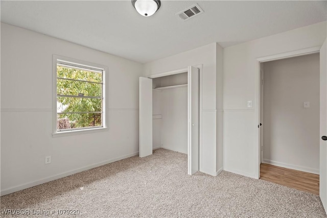 unfurnished bedroom with carpet floors, visible vents, and baseboards