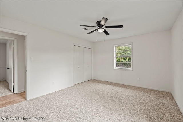 empty room featuring a ceiling fan, light carpet, visible vents, and baseboards