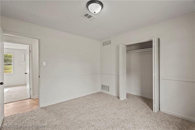 unfurnished bedroom with visible vents and light carpet