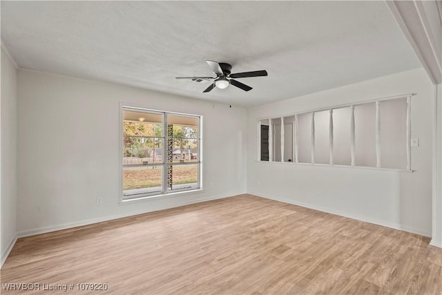 unfurnished room with light wood-style floors, baseboards, and a ceiling fan