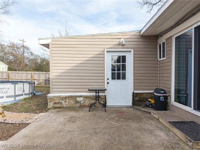 entrance to property featuring a fenced in pool and a patio