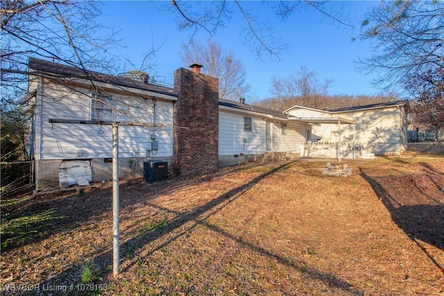 back of house featuring crawl space, central AC, and a chimney