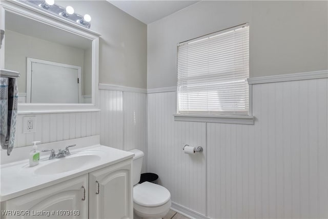 bathroom featuring wainscoting, vanity, and toilet