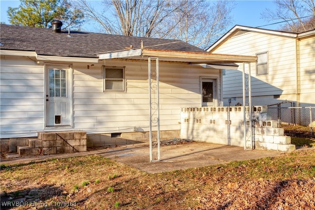 rear view of house featuring crawl space, roof with shingles, fence, and a patio