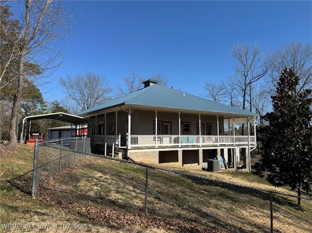 farmhouse-style home with fence, covered porch, metal roof, a carport, and driveway