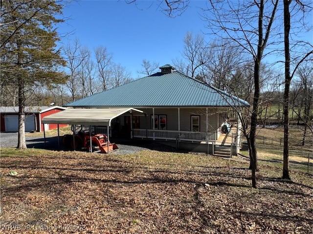 exterior space featuring a chimney, covered porch, and metal roof