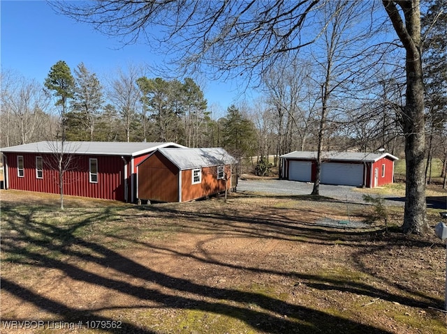 view of property exterior with an outbuilding, a garage, and dirt driveway