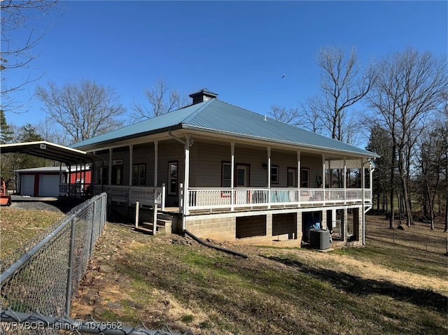 farmhouse with covered porch, metal roof, an outdoor structure, a carport, and driveway