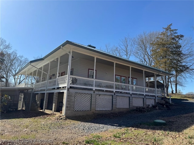 rear view of property with stairway and covered porch