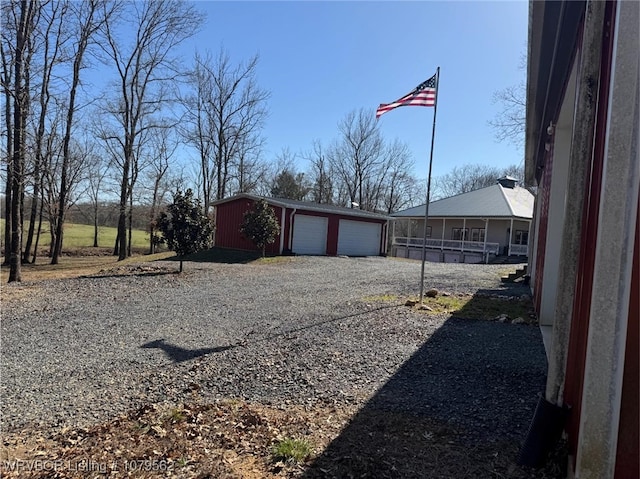 view of yard featuring a garage and an outbuilding