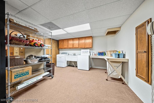 laundry area featuring washer and dryer, sink, light colored carpet, and cabinets