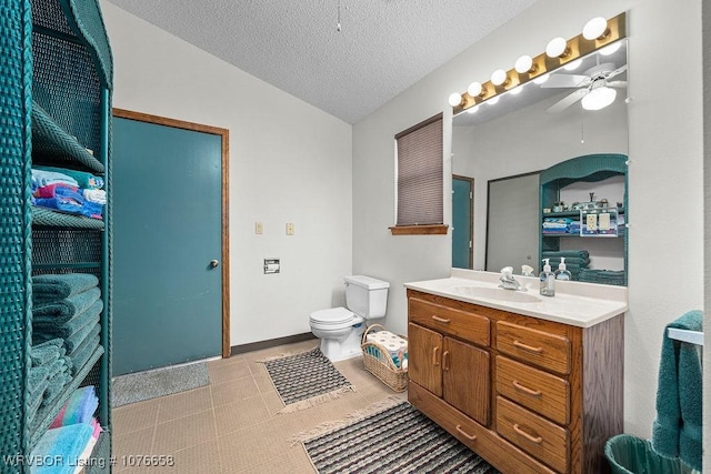 bathroom featuring vanity, a textured ceiling, ceiling fan, tile patterned flooring, and toilet