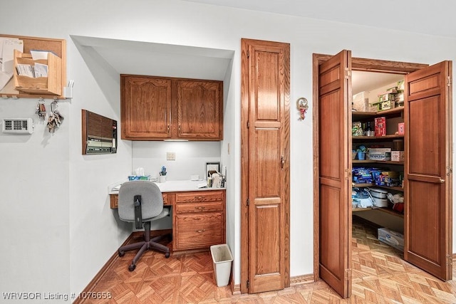 office with light parquet floors and built in desk