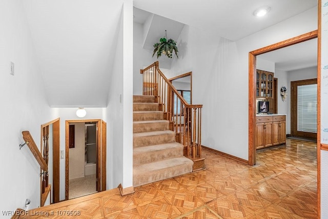 stairway featuring parquet flooring