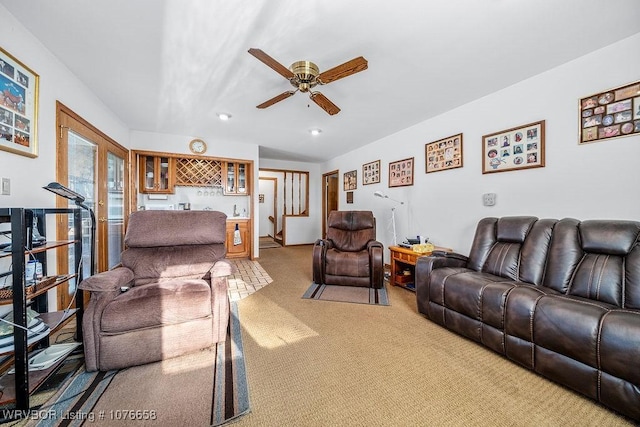 living room with bar area, carpet floors, and ceiling fan