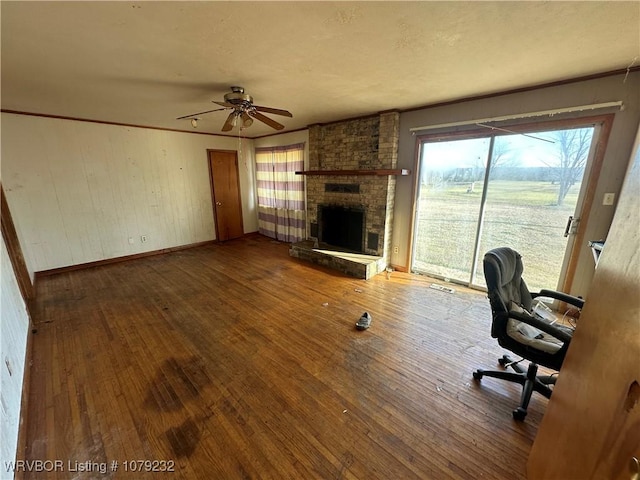 unfurnished office featuring a fireplace, visible vents, a ceiling fan, baseboards, and hardwood / wood-style flooring