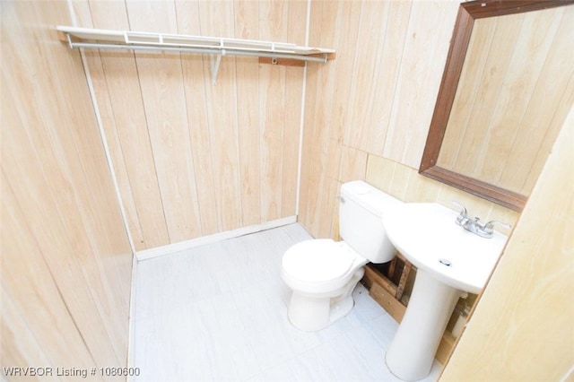 bathroom with wooden walls and toilet